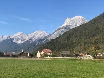 Houses on field by mountain against sky