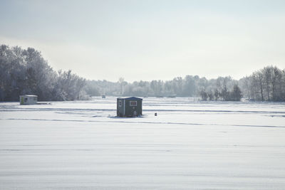 Scenic view of snow covered field against sky