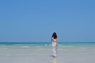 Full length of woman on beach against clear sky