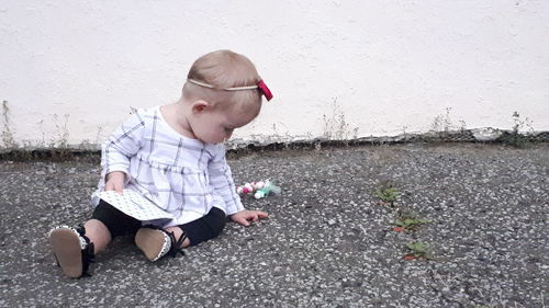 Boy looking at camera while sitting on wall