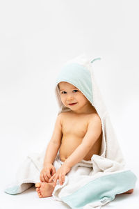 Portrait of cute girl sitting against white background