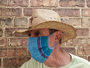 Portrait of man wearing hat against wall