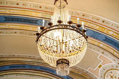 Low angle view of chandelier hanging on ceiling of building