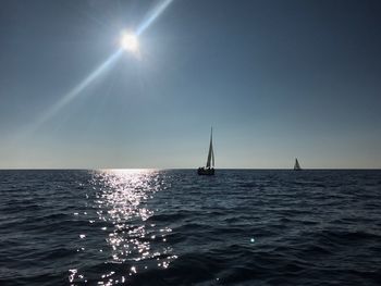 Sailboat sailing on sea against clear sky