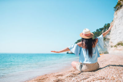 Full length of woman on beach against clear sky