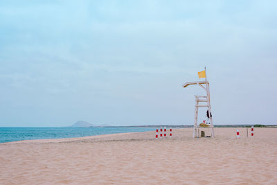 Lifeguard hut on beach against sky
