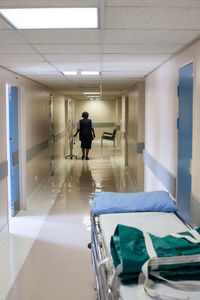 Rear view of man walking in corridor of building