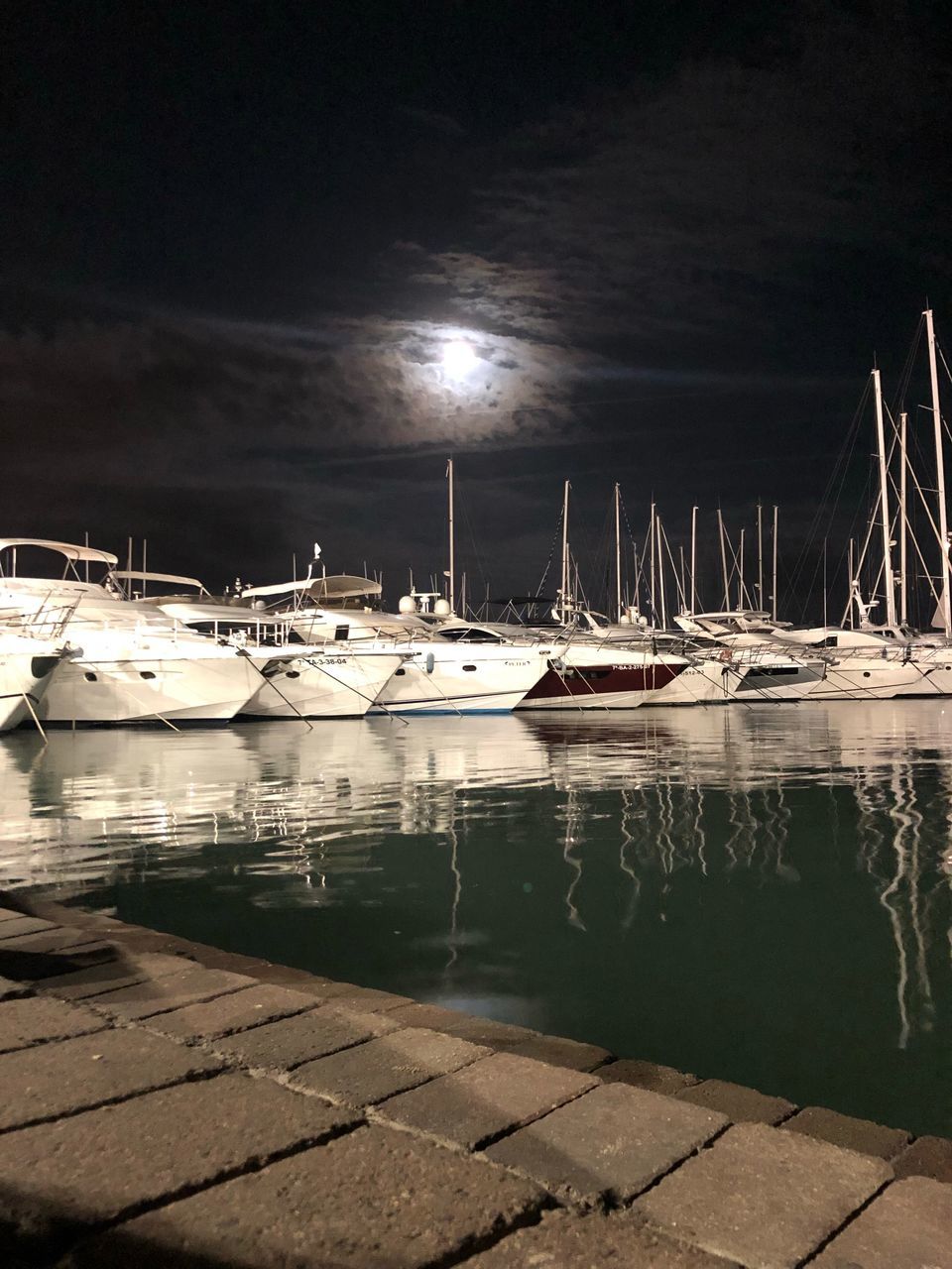 SAILBOATS MOORED IN HARBOR AT NIGHT