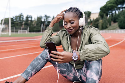 Full length of young woman using mobile phone