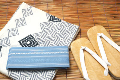 High angle view of fabrics with flip-flops on table