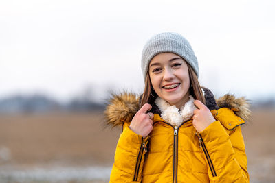 Portrait of woman wearing warm clothing standing against sky