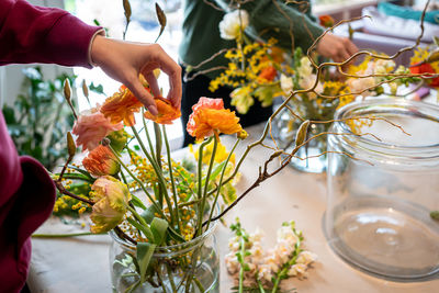 Women hands make bouquet at flower workshop