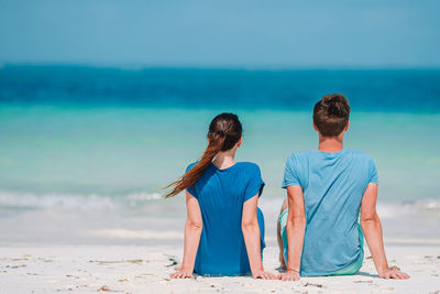 Rear view of friends enjoying at beach