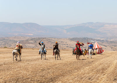 Group of people riding horses on land