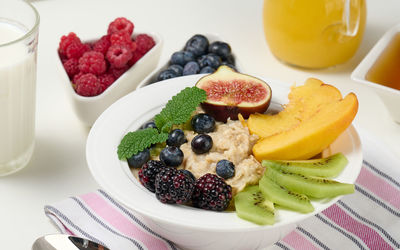Full plate with oatmeal and fruit, freshly squeezed juice in a transparent glass 