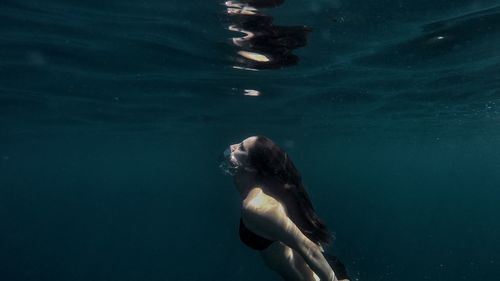 Side view of young woman swimming in sea