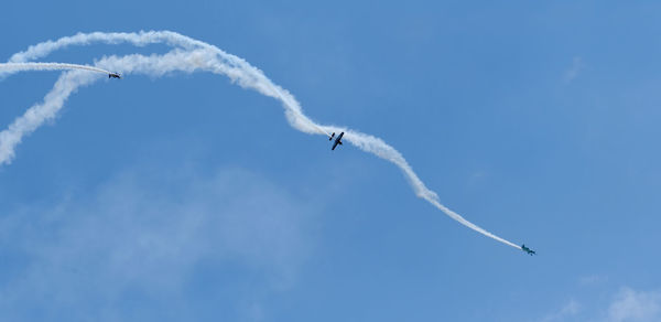 Low angle view of airplane flying against blue sky