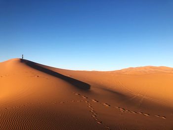 Scenic view of desert against clear blue sky