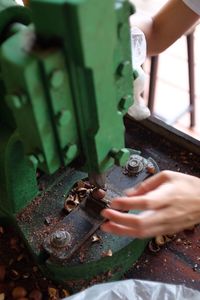 Cropped hands of worker crushing nuts using machine at workshop