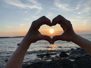 Heart shape on beach against sky during sunset