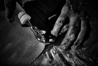 Cropped hands cutting dough in kitchen