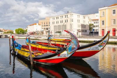 Boats moored in canal against buildings in city