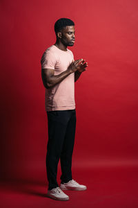 Young man looking away against red background