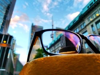 Close-up of sunglasses on car against sky