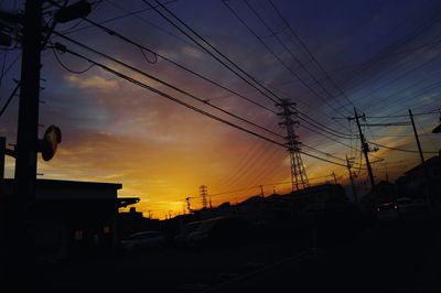 Low angle view of electricity pylon against dramatic sky