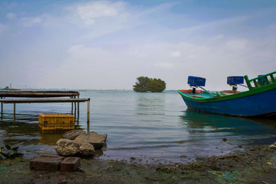 Boat moored on sea against sky