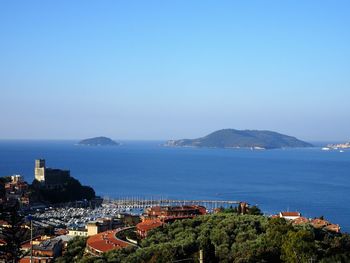 High angle view of city by sea against clear sky