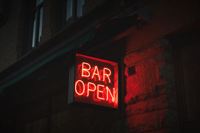 Low angle view of illuminated sign on building at night