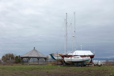 Sailboats moored on sea against sky