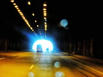 Illuminated tunnel at night