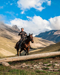 Rider caucasian girl on a horse gallops through a mountain valley