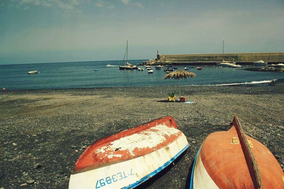 water, sea, horizon over water, beach, nautical vessel, transportation, sky, land, horizon, mode of transportation, nature, day, scenics - nature, beauty in nature, incidental people, tranquil scene, sand, moored, outdoors, fishing industry