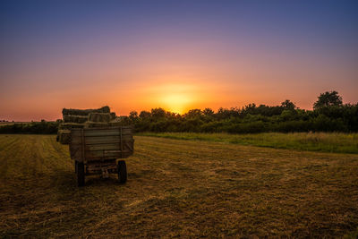 Vehicle on field during sunset