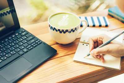 Midsection of woman using laptop on table