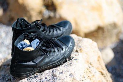 High angle view of black shoes on rock