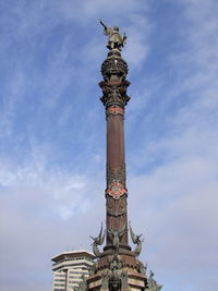 Low angle view of christopher columbus monument against cloudy sky