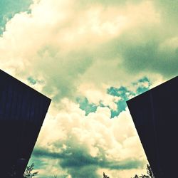 Low angle view of buildings against cloudy sky