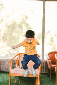 Full length of girl sitting on chair