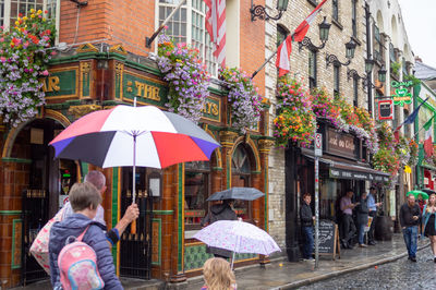 People on wet street in city during rainy season