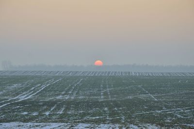 Scenic view of field against sky during winter
