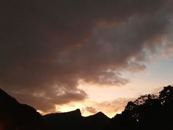 Low angle view of silhouette mountain against dramatic sky