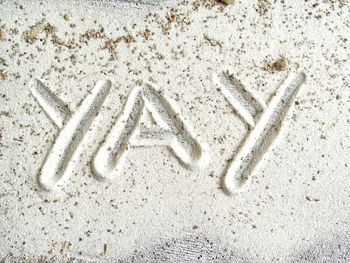 High angle view of text on sand