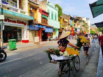 People riding bicycle on road in city