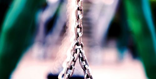 Close-up of chain hanging against blurred background