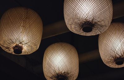 Low angle view of illuminated light fixtures hanging from ceiling