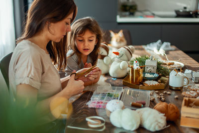 Happy friends sitting on table